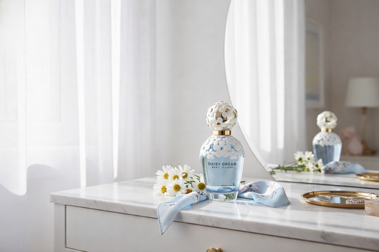 Perfume bottle with floral design on a white surface near a window